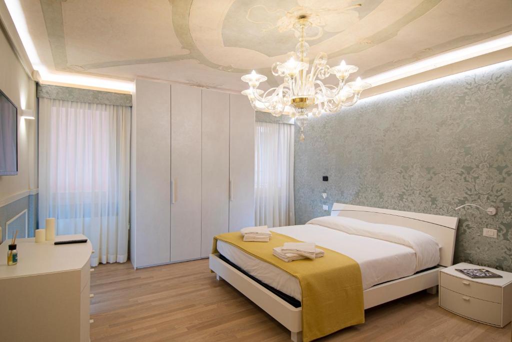 威尼斯的住宿－CA' XXII MARZO BOUTIQUE，一间卧室配有一张大床和一个吊灯。