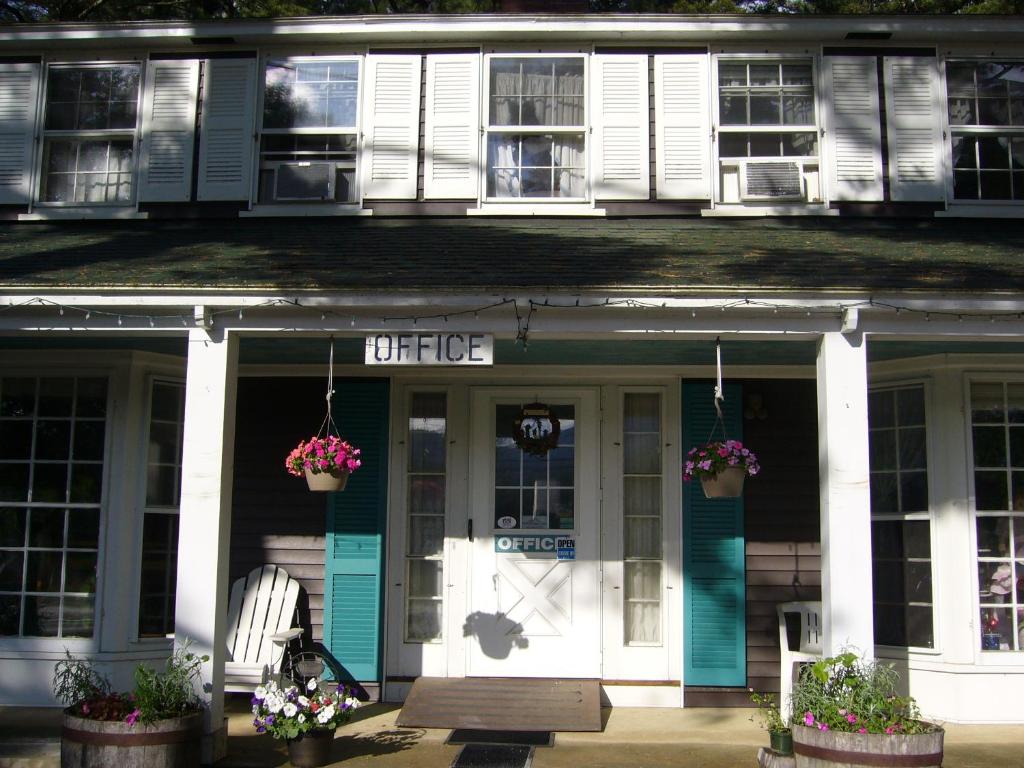 una casa más antigua con una puerta azul y blanca y flores en White Trellis Motel, en North Conway