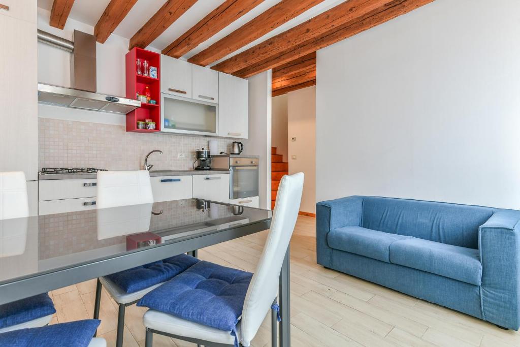 a kitchen and living room with a blue couch at Colombina's roof in Venice