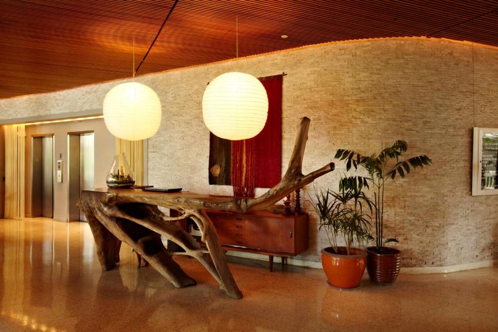 a room with a wooden table and a mirror at The Standard Miami in Miami Beach