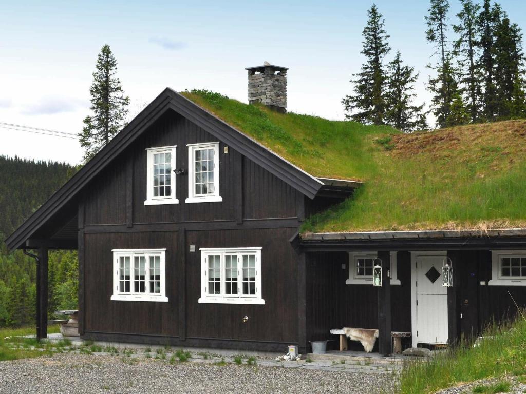 uma casa preta com telhado de relva em Holiday Home Vestsiden III em Tromsnes