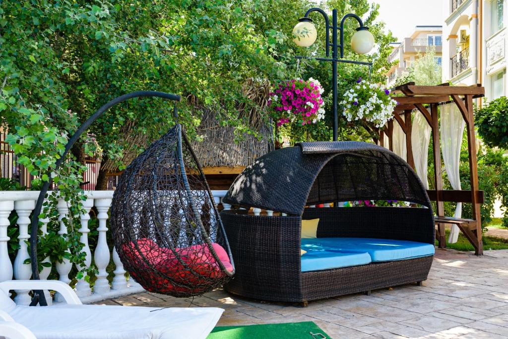 a bird cage and a hammock on a patio at Sweet Homes Apartments in Sunny Beach