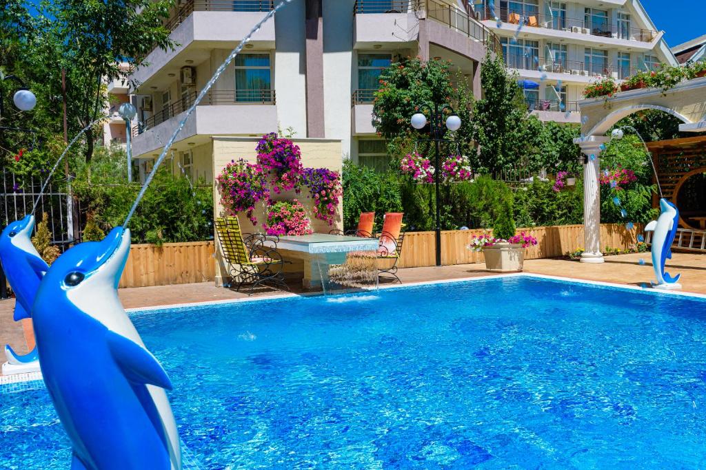 a pool with a blue dolphin in a yard at Sweet Homes Apartments in Sunny Beach