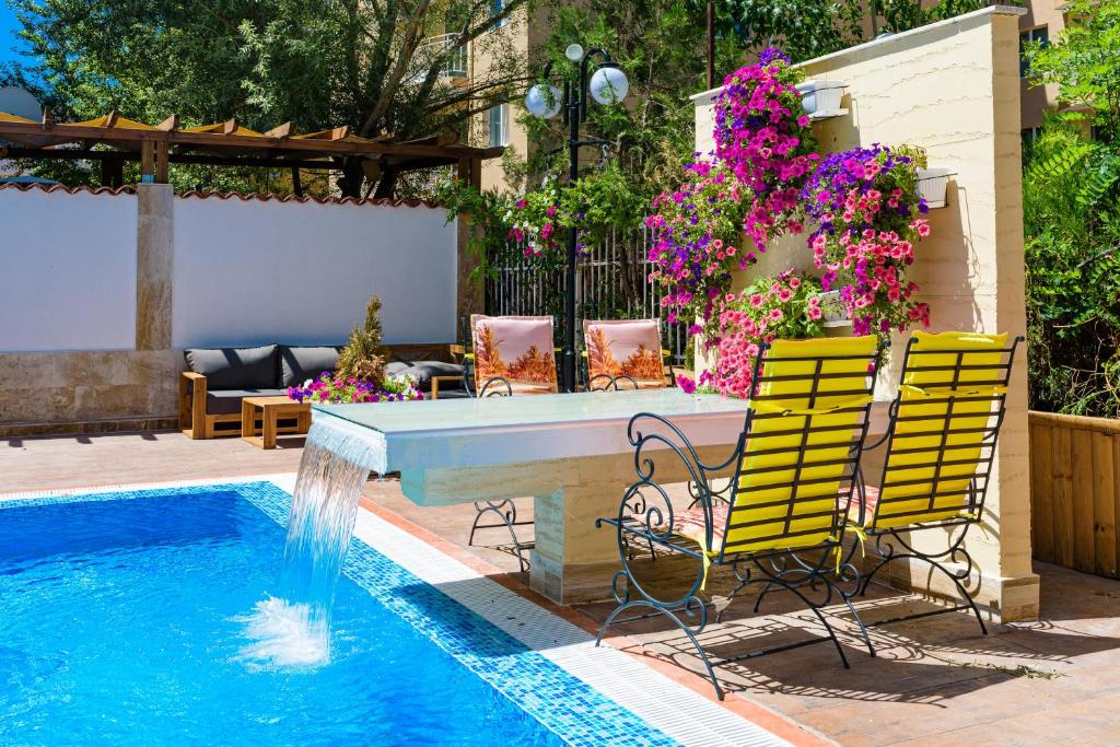 a pool with two yellow chairs next to a swimming pool at Sweet Homes Apartments in Sunny Beach