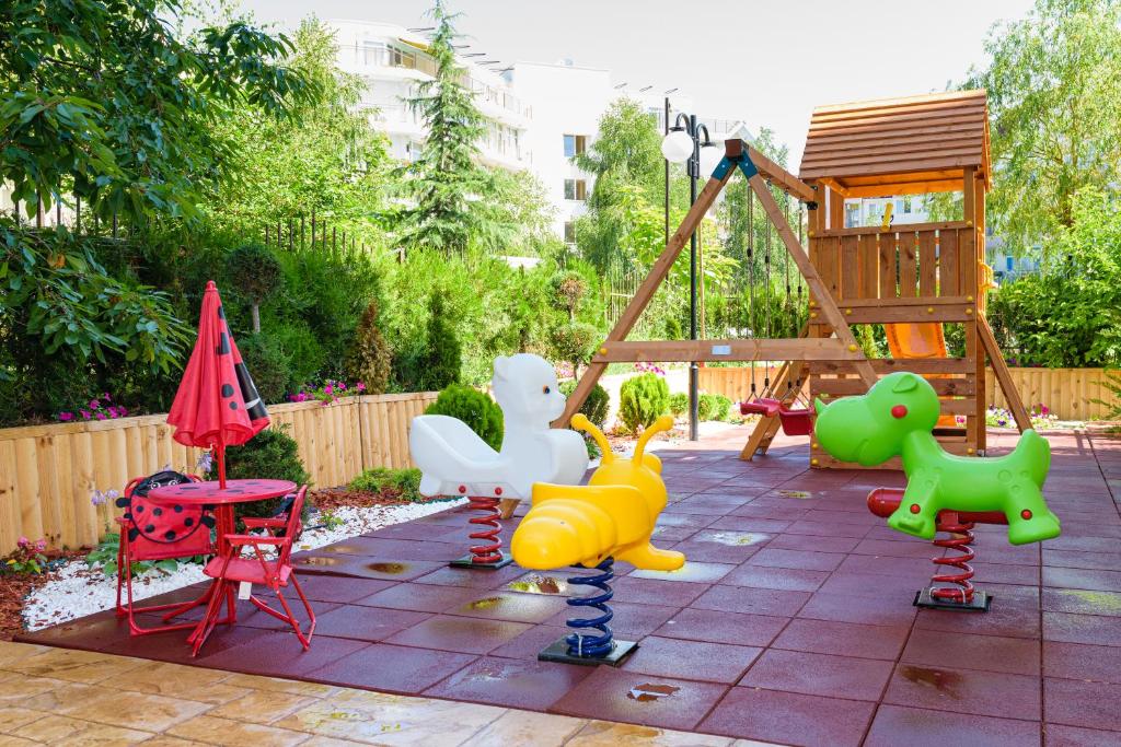 a playground with colorful play equipment in a backyard at Sweet Homes Apartments in Sunny Beach