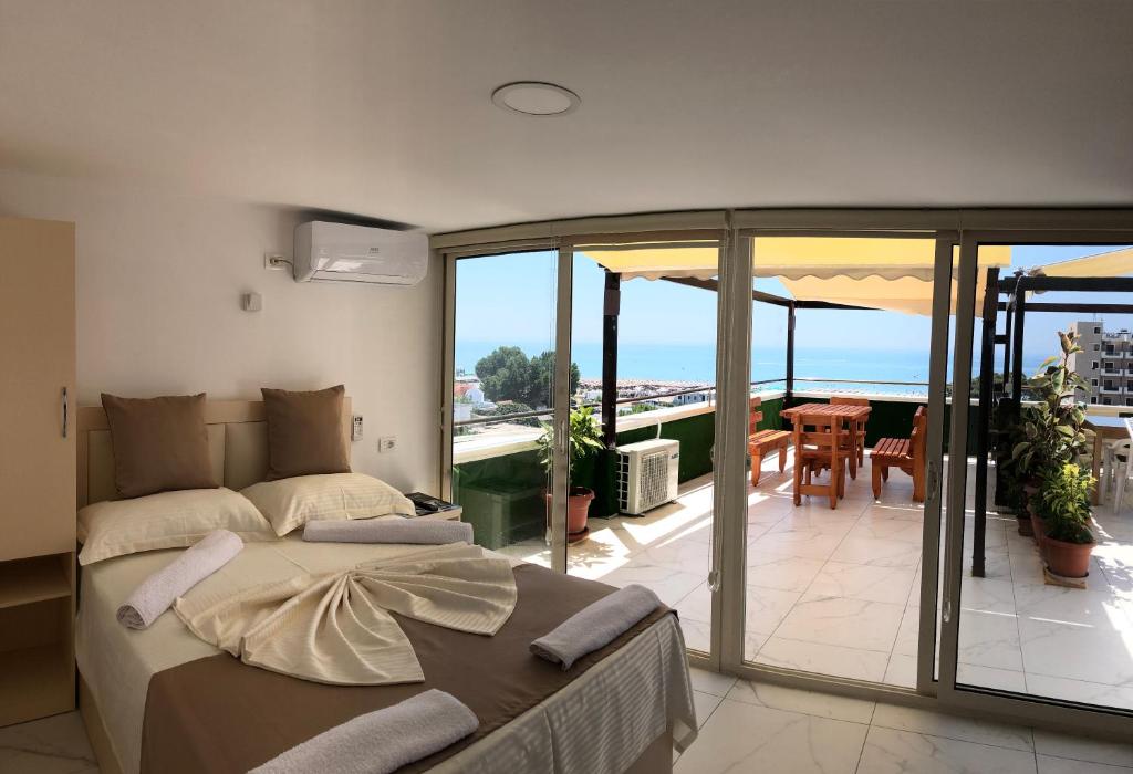 1 Schlafzimmer mit einem Bett und einem Balkon mit Aussicht in der Unterkunft Hotel Perdja in Velipojë