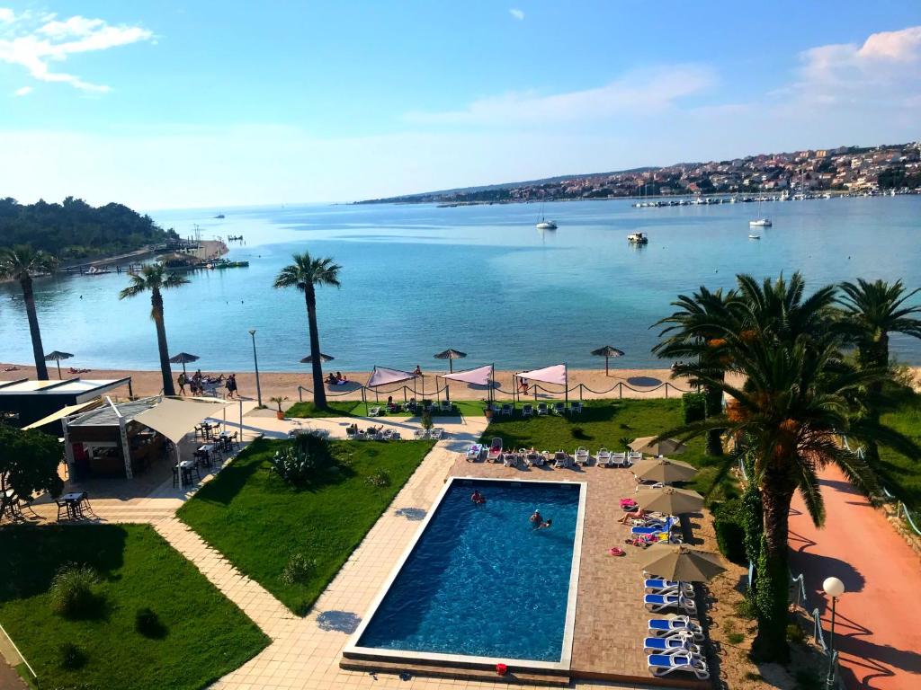 Blick auf den Strand und den Pool in einem Resort in der Unterkunft Liberty Hotel in Novalja