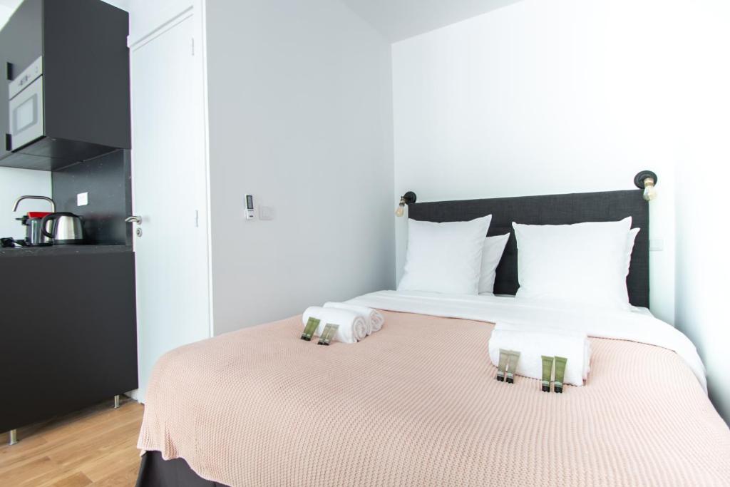 a bedroom with a large bed with two pillows at Dreamyflat - Bastille in Paris