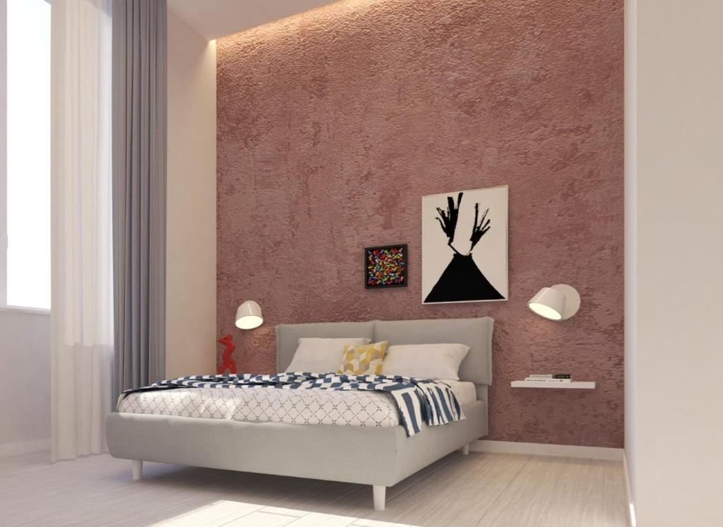 1 dormitorio con cama y pared de color rosa en N'Agorà B&B, en Nápoles
