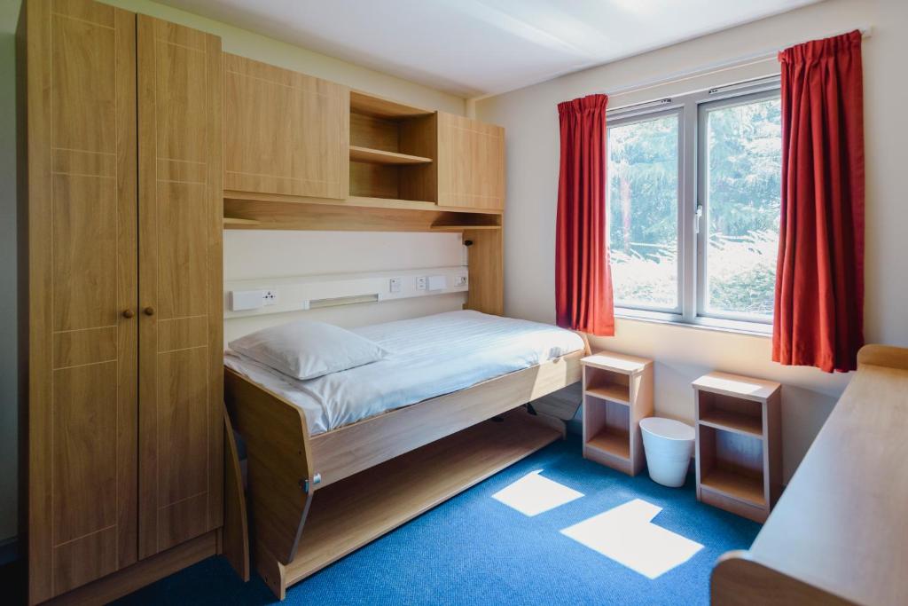 a small bedroom with a bed and a window at Glasney Rooms, University Campus Penryn in Falmouth