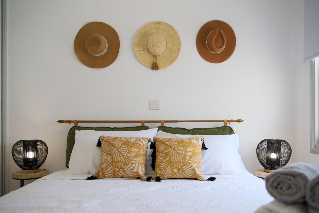 ein Schlafzimmer mit einem Bett mit Hüten an der Wand in der Unterkunft Phaedrus Living: Seaside Luxury Flat Lighthouse 68 in Paphos City