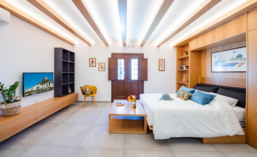 duży pokój z łóżkiem i telewizorem w obiekcie IN Lindos w Líndos