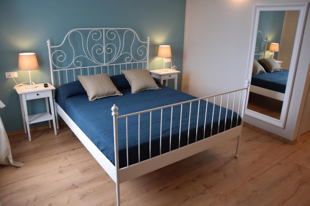 a bedroom with a bed with a blue mattress and a mirror at Le camere della Nonna in Diano Marina