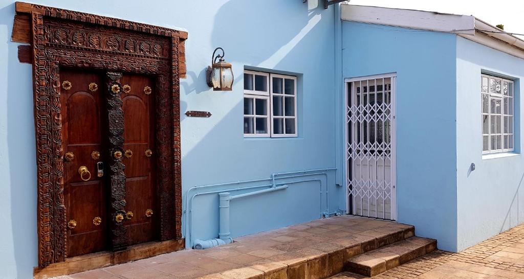 a blue building with a wooden door and stairs at Back-Up Power with Stable WiFi! Central in Walmer in Port Elizabeth