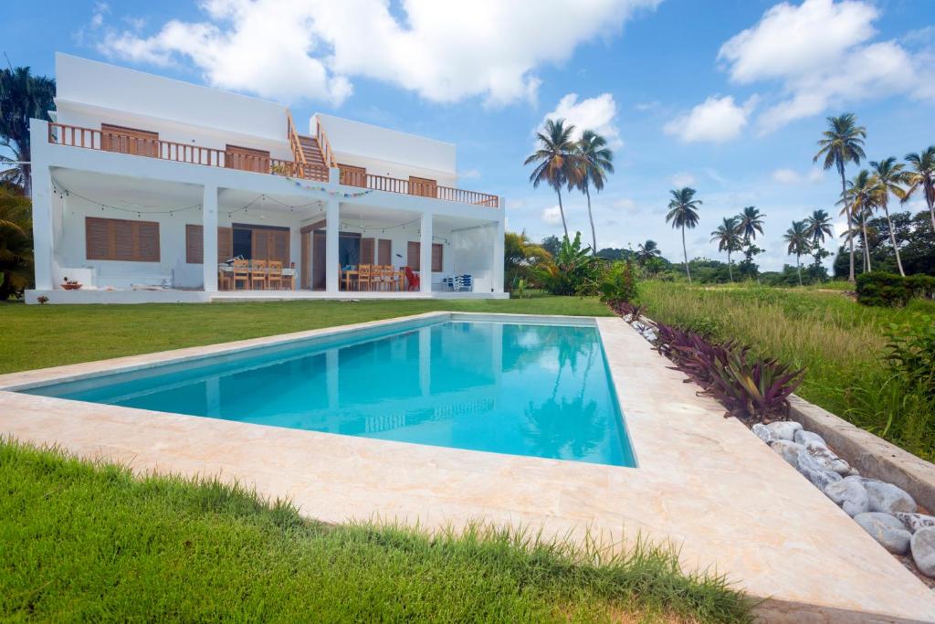 a villa with a swimming pool in front of a house at Casa Blava in Las Galeras