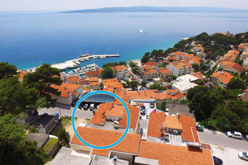 a building with a blue circle on top of it at Apartments & rooms Merita in Brela