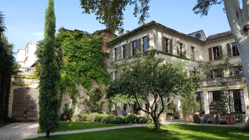 un gran edificio blanco con árboles delante de él en La Divine Comédie-Suites Deluxe en Aviñón