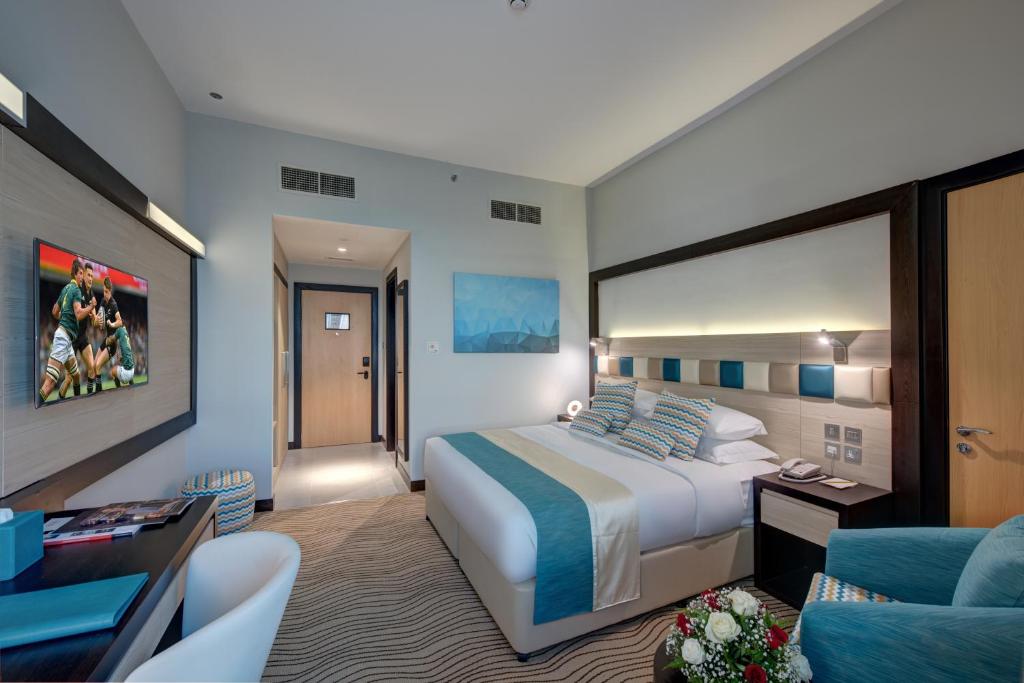 a hotel room with a bed and a living room at City Avenue Hotel in Dubai