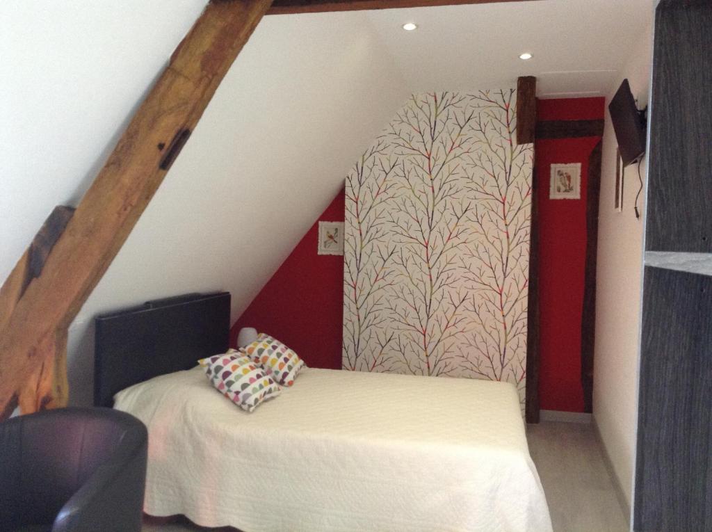 a attic room with a bed and a staircase at Chambre d&#39;hôte du HOUSSAY in Valennes