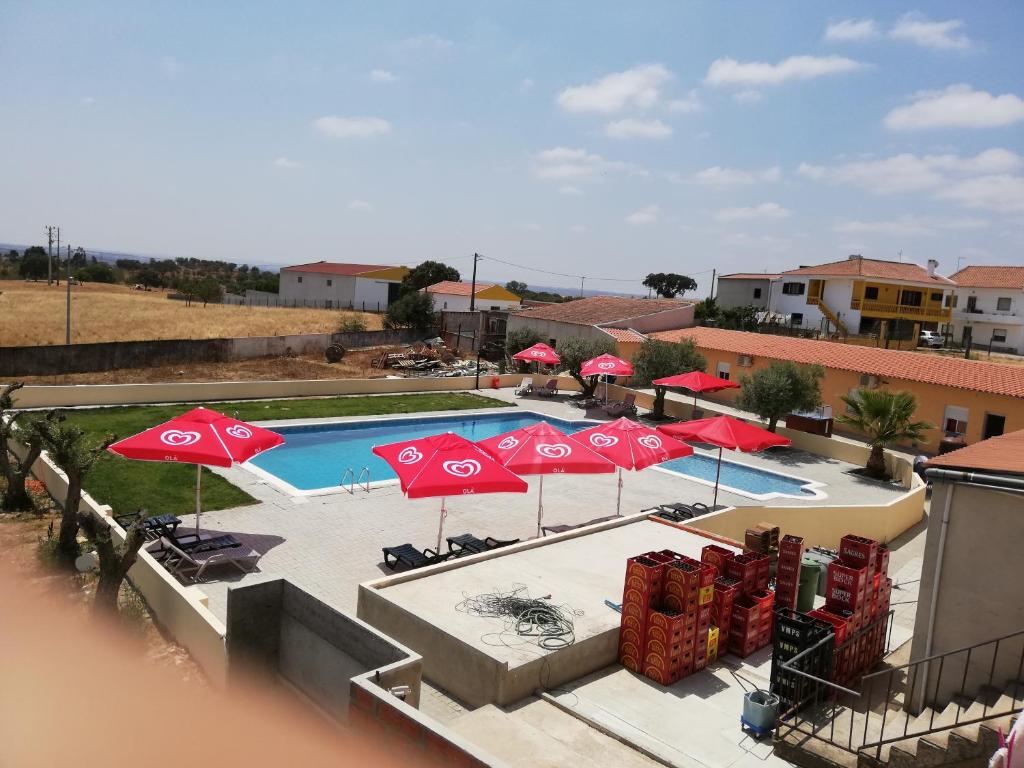 vistas a una piscina con sombrillas y sillas en Nefama Pensao en Ourique