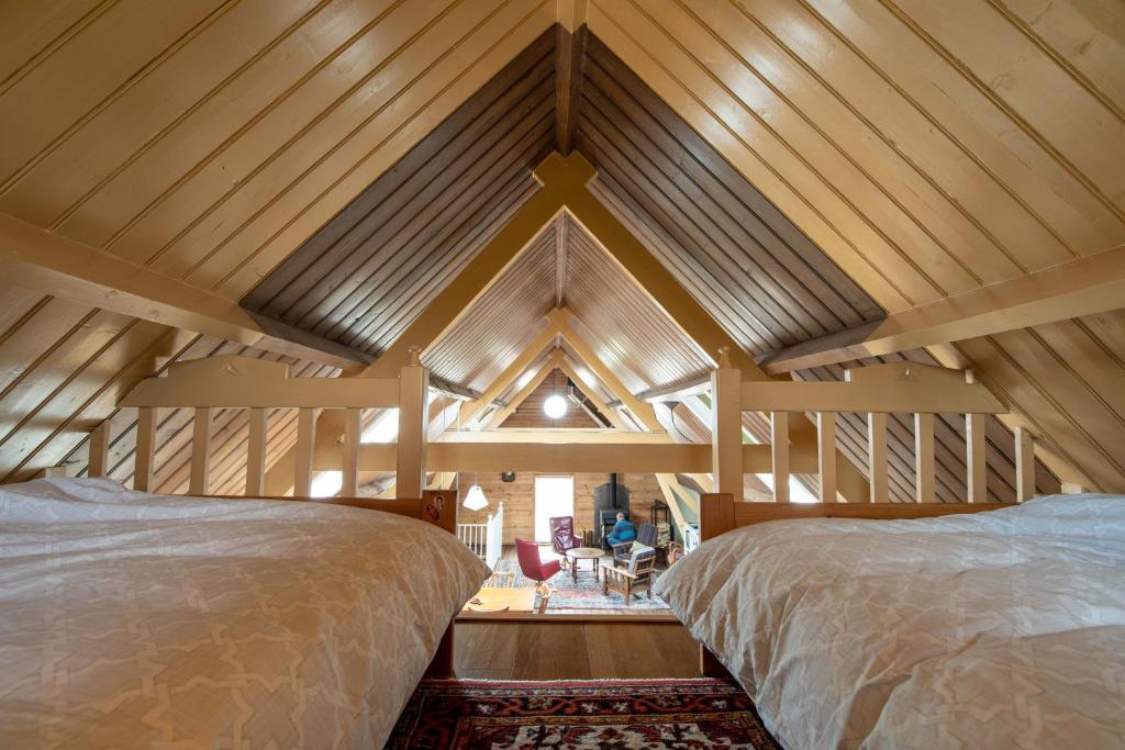 2 bedden in een kamer met houten plafonds bij bnb De Loft in Kloosterzande