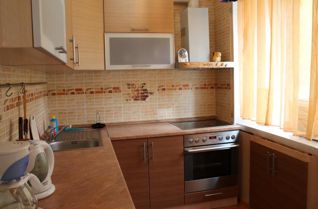 uma cozinha com um lavatório e um fogão forno superior em Apartment on Dusi Kovalchuk 272/4 em Novosibirsk