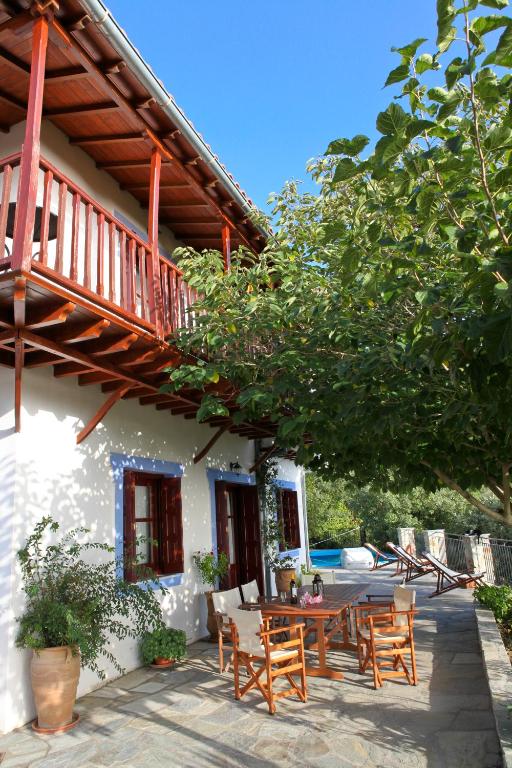 patio ze stołem i krzesłami przed domem w obiekcie Villa Maria O w mieście Skopelos