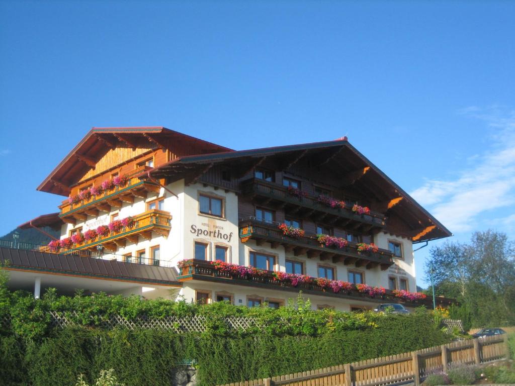 a large white building with a brown roof at Hotel Sporthof in Schladming