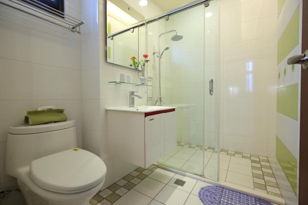 a white bathroom with a toilet and a shower at 花蓮知卡宣民宿 in Ji&#39;an