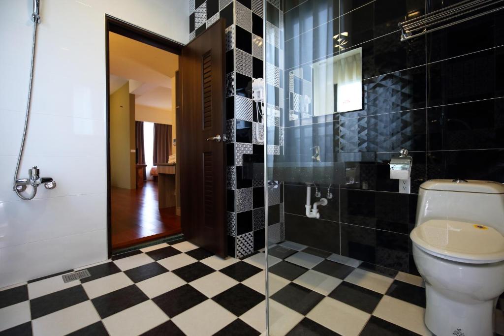 a bathroom with a toilet and a black and white checkered floor at 花蓮知卡宣民宿 in Ji&#39;an