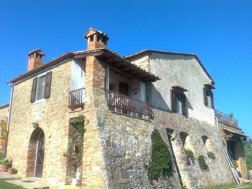 un gran edificio de piedra con balcón en la parte superior. en Due Piani, en Barberino di Val d'Elsa