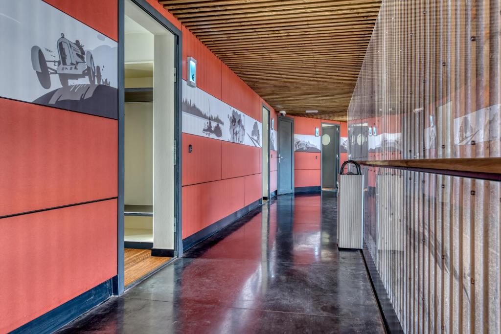 a corridor of a building with red walls at Le Merceny Motel in Bastogne