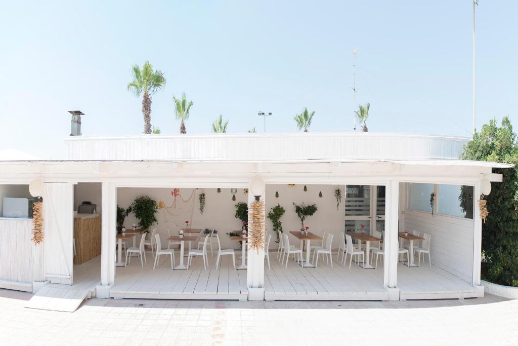 a white pavilion with white tables and chairs at Hotel San Giovanni in Polignano a Mare