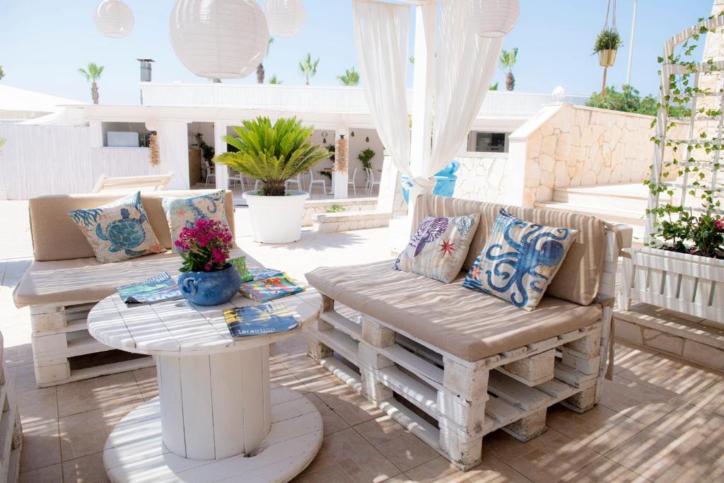 a patio with two benches and a table at Hotel San Giovanni in Polignano a Mare