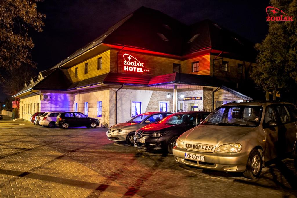 um grupo de carros estacionados em frente a um hotel em Hotel Zodiak em Radomsko