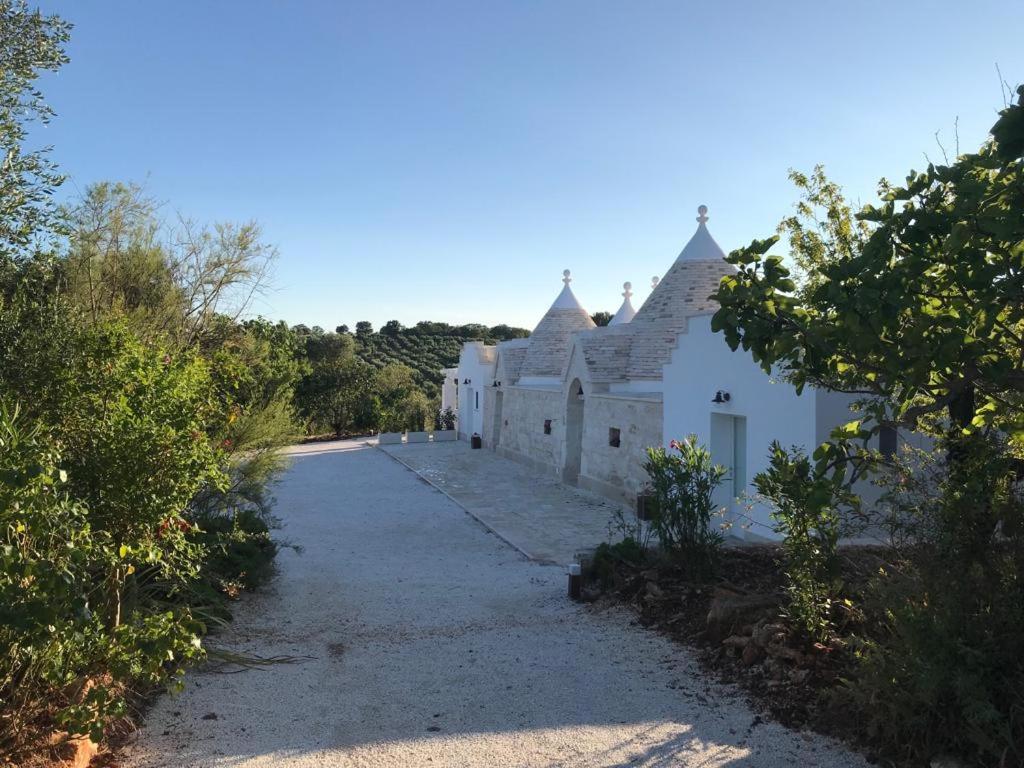 a group of white buildings on a dirt road at Trulli Pietraverde in Ceglie Messapica