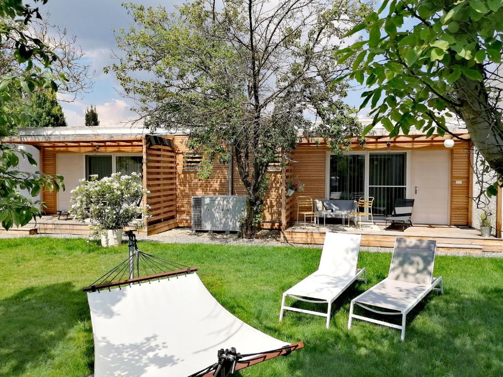 a backyard with two chairs and a house at The Parcels Hotel - Adults Only in Podersdorf am See