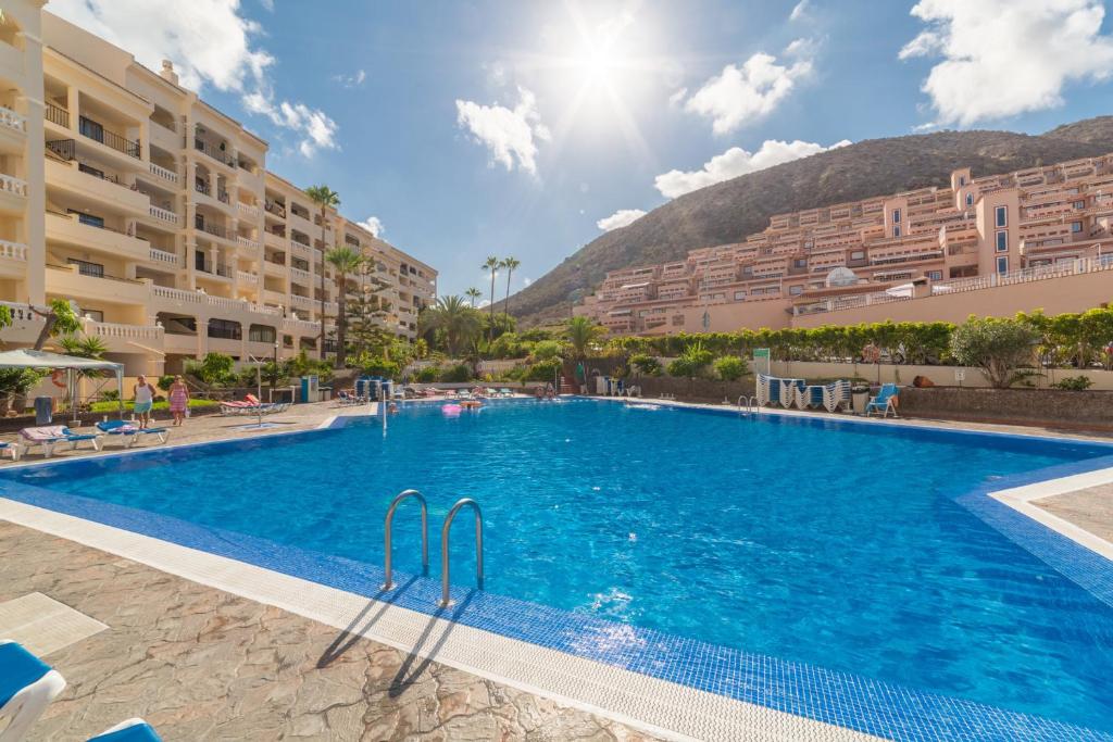 a large swimming pool in a resort with buildings at Casa Sara en Los Cristianos in Los Cristianos
