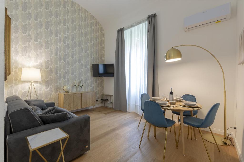FLORENCE FIORINO APARTMENT في فلورنسا: غرفة معيشة مع أريكة وطاولة وكراسي