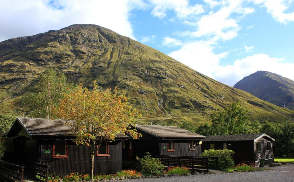 a mountain with two houses in front of it at Birch Chalet in Ballachulish
