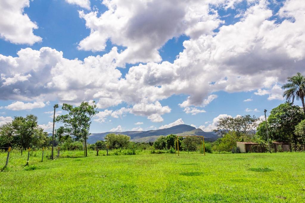 un champ d'herbe verte avec des montagnes en arrière-plan dans l'établissement Pousada Portal da Serra, à São João Batista do Glória