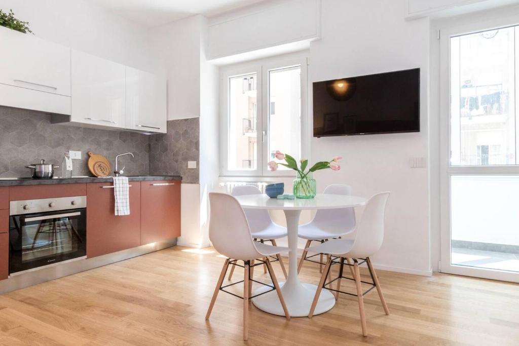 a kitchen with a white table and chairs in a room at ALTIDO Bright Apartment for 4 next to City Life in Milan