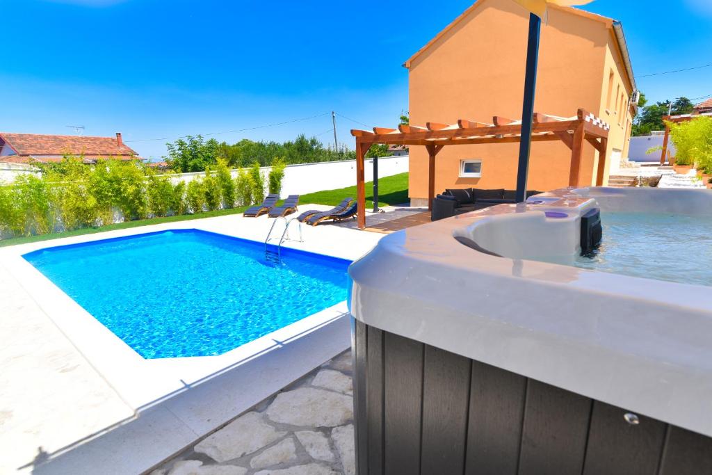 Bazén v ubytovaní Villa Village Idylle with heated pool, sauna, jacuzzy and private parking alebo v jeho blízkosti