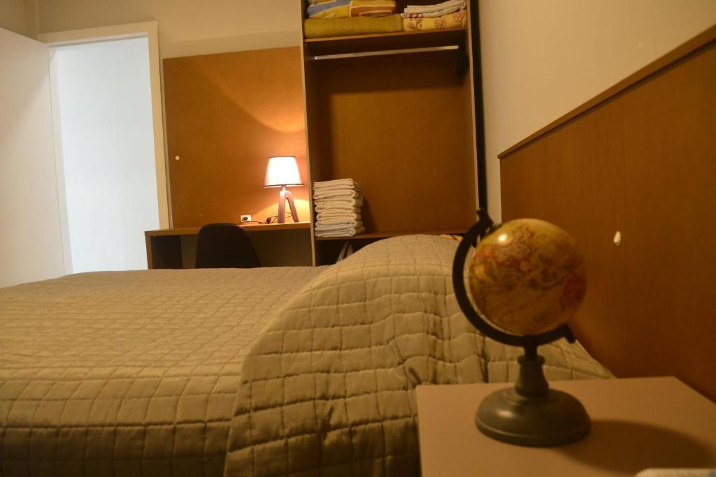a hotel room with a bed and a globe on a table at CASA PRAIA A 600m DO MAR in Balneário Camboriú