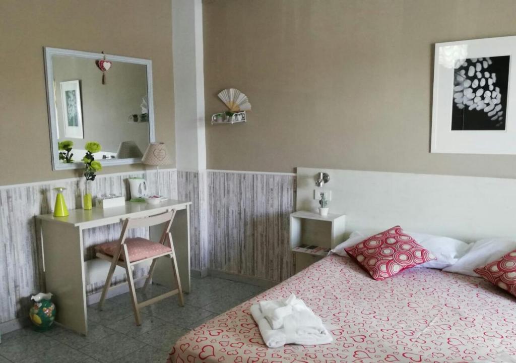 a bedroom with a bed and a desk and a mirror at B&B Sweet Home Two Steps From The Ruins... in Pompei