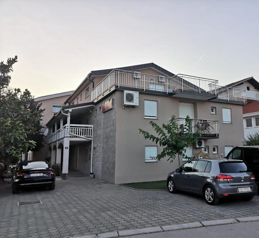 un edificio con dos coches estacionados frente a él en Rooms Kenedy, en Međugorje