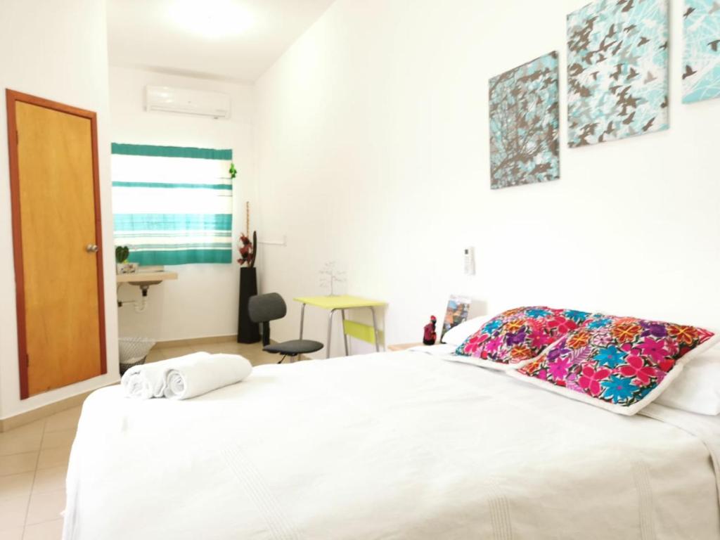 a bedroom with a white bed and a desk at Terraza Sancris in Tuxtla Gutiérrez