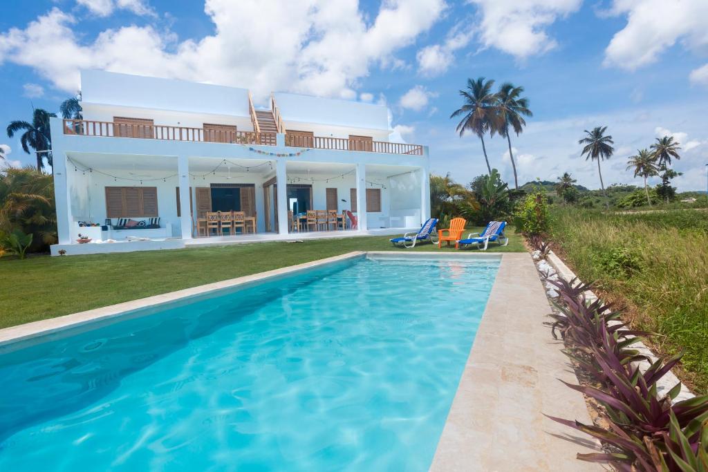a villa with a swimming pool in front of a house at Villa Cuatro Peces in Las Galeras