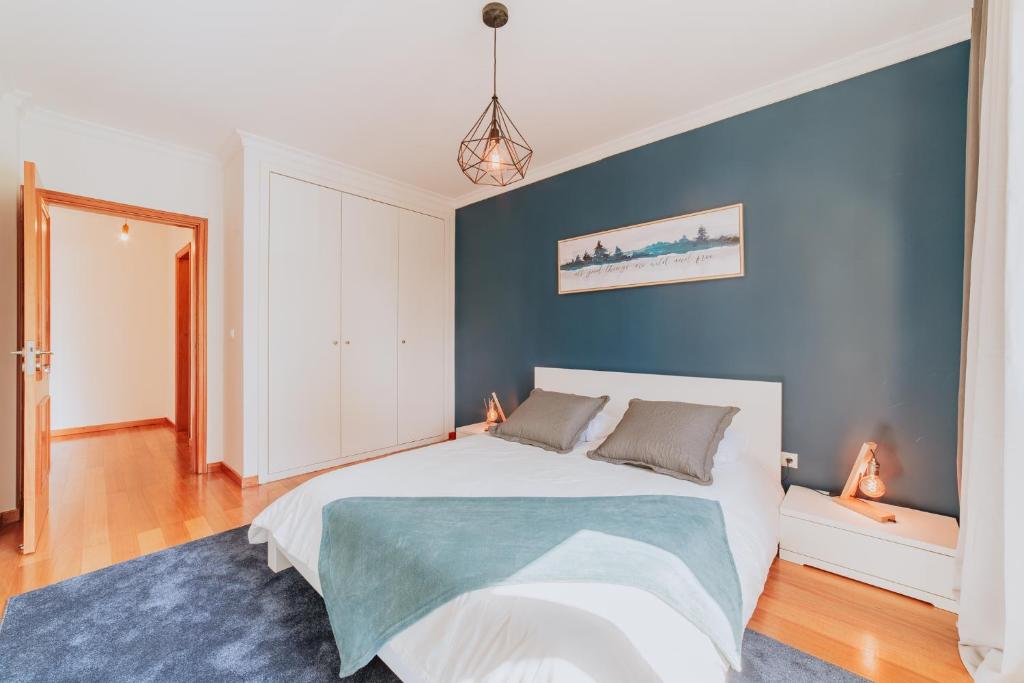 een slaapkamer met een bed en een blauwe muur bij Funchal Lounge Apartment II in Funchal