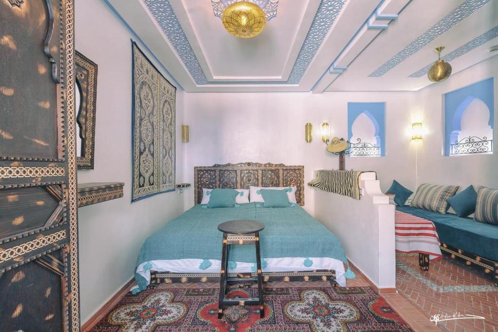 una camera con un letto, un letto e un divano di Dar Rafik a Chefchaouen